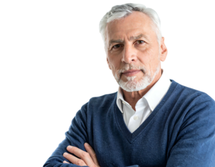 A senior man, with graying hair and beard, gazes directly at the viewer with arms crossed, wearing a blue sweater and white collared shirt