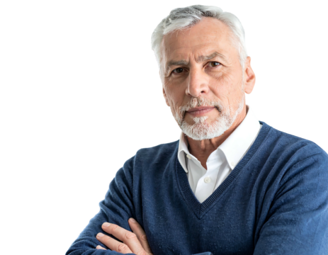 A senior man, with graying hair and beard, gazes directly at the viewer with arms crossed, wearing a blue sweater and white collared shirt