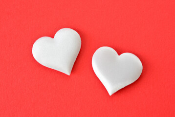 Two Soft White silk Hearts on a Vibrant Red Background