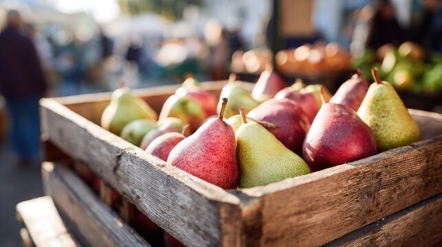 Fresh ripe red and green pears in wooden crate at farmer's market stall