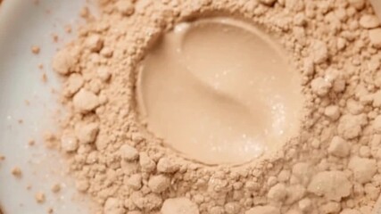 Luxurious mineral makeup powder swirling in elegant container for beauty product demonstration and cosmetic marketing campaigns