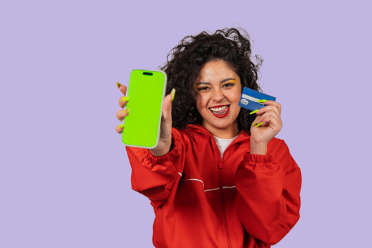 Woman holding smartphone with green screen and credit card - Powered by Adobe