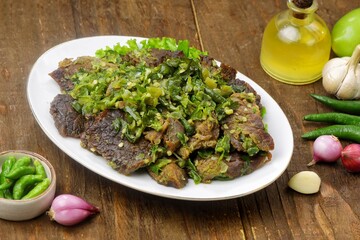 Dendeng Batokok Cabe Ijo is a dish rich in flavor and texture, combining tender beef jerky with fresh and spicy green chili sauce.