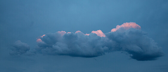 close up Reflection of sunlight in sunset clouds. A beautiful pink cloud against a background of blue clouds