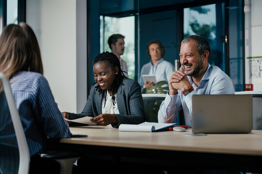 Diverse Business Team Meeting in Modern Glass Office