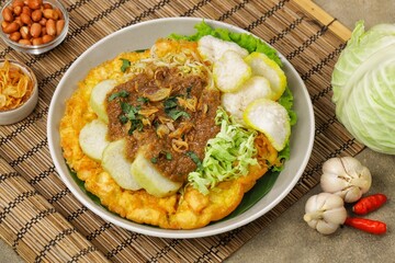 Tahu tek, tahu gunting, tahu telur is a typical Surabaya food consisting of fried tofu, rice cake, fried potatoes, bean sprouts and cucumber, which are drizzled with peanut sauce.