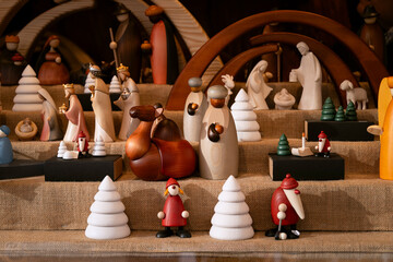 Small wooden figurines depict the characters of Christmas: shepherds, animals, a Nativity scene carved with care.