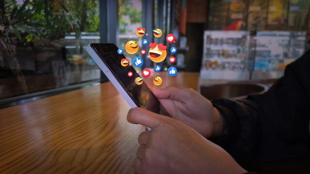 Smartphone with Floating Social Media Reactions in Cafe Setting - Powered by Adobe