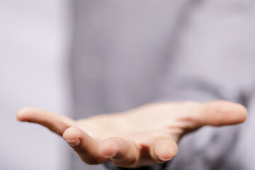 Close-up of a hand held out in a gesture of offering, giving, or requesting. The open palm suggests...