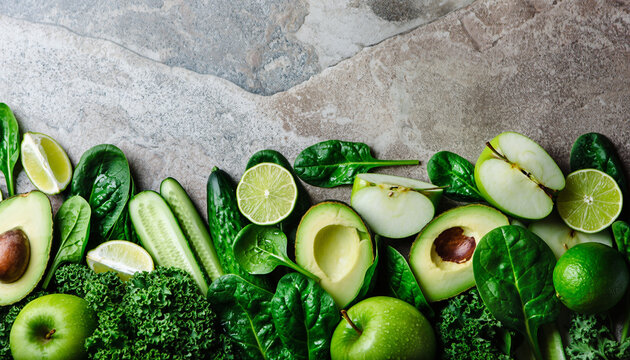 A vibrant, overhead shot capturing a border frame of various green vegetables and fruits (kale, spinach, avocado, cucumber, lime, apples) on a natural stone surface, promoting a raw, healthy, and deto - Powered by Adobe