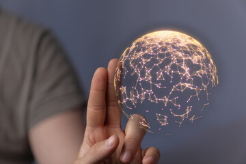Abstract image of a hand holding a glowing digital sphere representing global connection,...