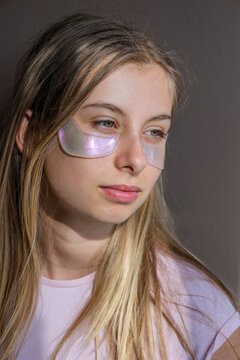 preteen girl using pink sparkling eye patches fun beauty concept