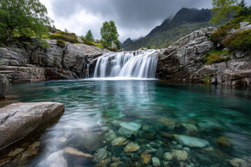 Waterfall cascading into crystal clear pool in mountain landscape