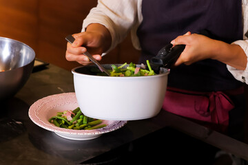 The chef is preparing a dish of shredded pork with garlic sprouts.