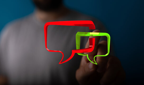 Conceptual image with hand touching red and green chat bubbles for message delivery, conveying communication or social networking.