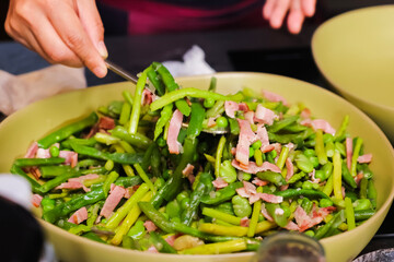 The chef is preparing a dish of shredded pork with garlic sprouts.