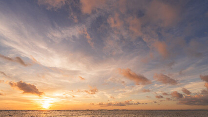 Sunset sky clouds over sea water background in evening with orange, blue sun light, Horizon sea ocean sunrise sky landscape nature backgrounds and gold sun down in golden hour summer season, Dusk sky