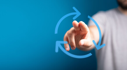Hand pointing towards a circular arrow icon, representing the idea of refresh, reload, or update. Business concept.