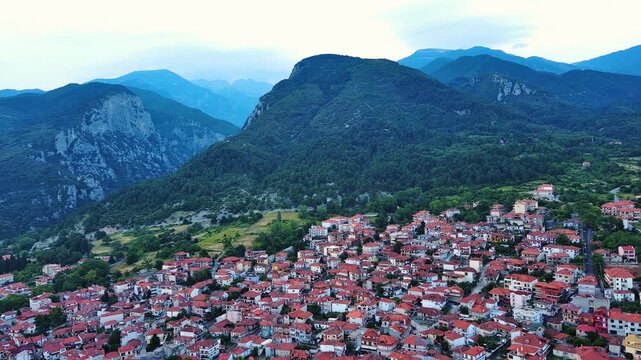 Greek town of Litochoro with small houses against the backdrop of the Mount Olympus and a cloudy sky