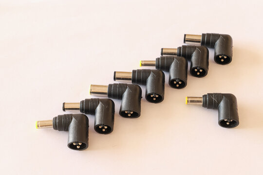 Close-up of angled power adapter plugs on a white surface