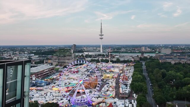 Panoramic view of Hamburger Dom in St pauli from above with amusement park by sunset and the tv tower in the background