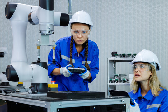 female automation machine engineer student study and inspection control robot arm machine in university or factory workshop. ai robot technology new innovation trend of manufacturing in industry 5.0