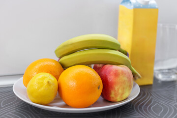 Fresh mixed fruit and milk carton on counter