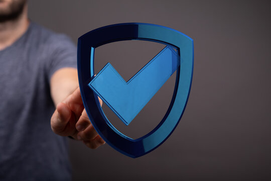 A person extending a hand offering a shield with a checkmark, representing security, validation, protection and assurance against fra
