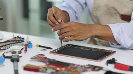 Electronic technician repairing tablet computer.