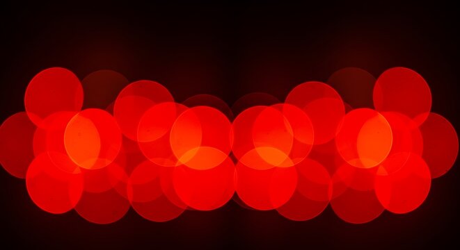Abstract bokeh lights background with a row of blurred red circles on a dark backdrop, creating a festive atmosphere