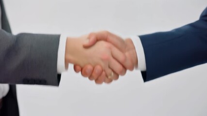 Close-up shot of two business people shaking hands in agreement and partnership on a white background, signifying a successful deal