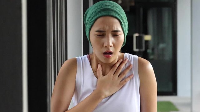 Asian woman cancer patient suffering from symptom relapse or negative side effect due to chemotherapy or radiation therapy breast cancer treatment