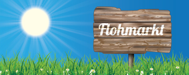 Ein Schild mit dem Wort Flohmarkt auf der Wiese vor blauem Himmel Header