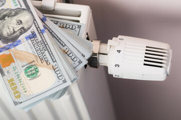 Money Stack on Heating Radiator Thermostat Symbolizing Cost