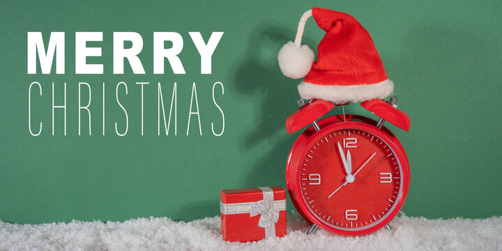 Merry Christmas, year 2025 or saint nicholas day, celebration holiday greeting card - countdown, santa hat on red retro alarm clock and gift box in snow, isolated on green background - Powered by Adobe