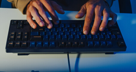 Closeup young adult male freelance developer typing write prompt AI bot app program nomad terminal coding at office night. Artificial intelligence dashboard, robotics user interface, machine learning.