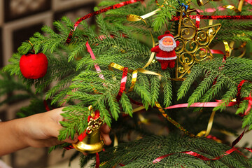 Christmas party or miracles and Santa Claus. Christmas tree with decoration. Close-up decorating Christmas tree with baubles balls on the background and santa claus small toy on tree and ball on tree.