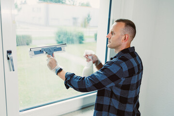 Cleaning windows with care while enjoying a sunny day indoors, showcasing attention to detail in a bright room
