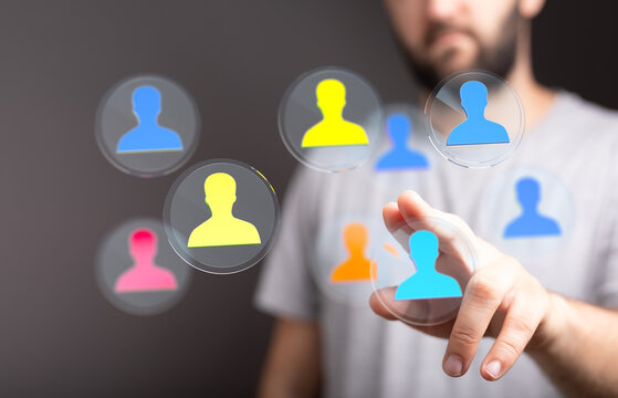 Businessman reaching towards a digital interface showing connected human icons, representing social networking, global communication and people. - Powered by Adobe
