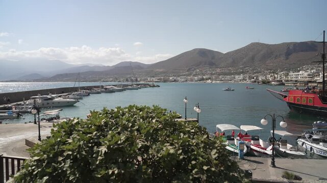 View of boats in Limenas Chersonisou Port on a sunny day, Limenas Chersonisou, Crete, Greek Islands, Greece, Europe