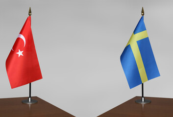 Table flags of Turkey and Sweden on grey blurred background