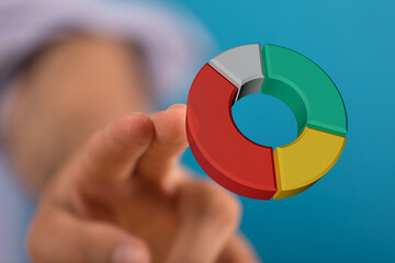 Hand pointing at colorful 3D pie chart, symbolising business strategy and analytics. Perfect for financial and marketing concepts.