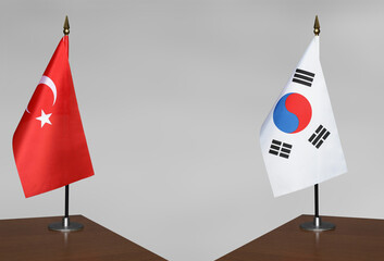 Table flags of Turkey and South Korea on grey blurred background