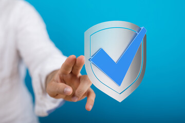 Concept of data security and digital protection. Hand touching a shield with a checkmark, symbolizing validation and agreement on blu