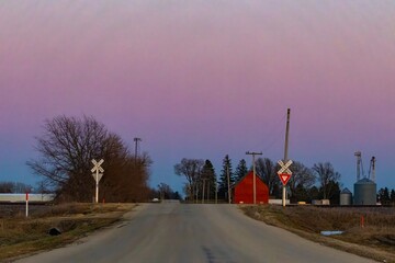 Rural Railroad Crossing at Dusk with Pink and Blue Sky