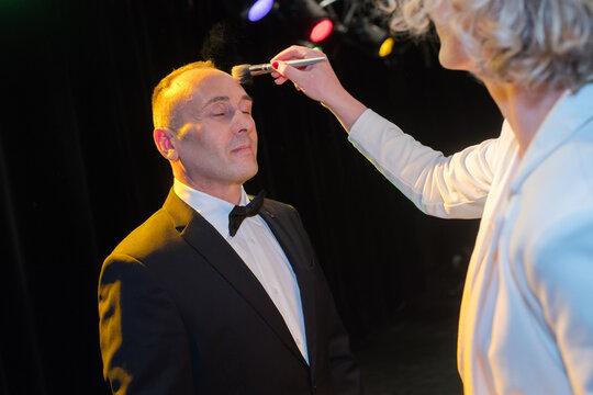 professional makeup artist working with man