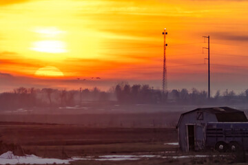 Rural Sunrise over Farmland with Barn and Communication Tower