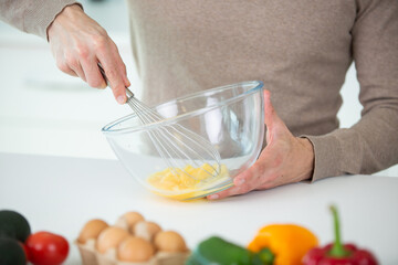 cropped image of man whisking eggs
