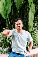 Serious Man Pointing Finger Directly at Viewer Outdoors