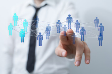 A businessperson's hand reaching towards a digital network of people symbolizing global connection and teamwork.